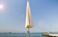 Sun umbrella overlooking the bay, pier and luxury boats on the Mediterranean coast, Juan les Pins, France