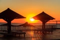 Sun umbrellas and chaise lounges on tropical beach at sunrise. Concept of rest, relaxation, holidays, resort Royalty Free Stock Photo