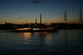 The sun went down outside the city. Above the city, electric high poles and pipes from the city's heating systems Royalty Free Stock Photo