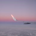 Sun at the wing of an aircraft flying in sunrise