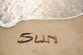 Sun written on the sand beach near sea - holiday relax concept Royalty Free Stock Photo