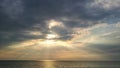 The sun's rays piercing the clouds above the sea Royalty Free Stock Photo