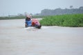 Sunamganj, Bangaldesh- October 11,2016: Passengers traveling by wooden engine boat in the rain and protecting by umbrella