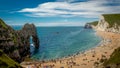 Sunbathers enjoying the warm sunshine on a weekend at Durdle Door