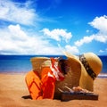 Sunbathing accessories on sandy beach in straw bag Royalty Free Stock Photo