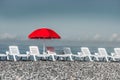 Sunbathing plastic beds and red umbrella on the beach Royalty Free Stock Photo