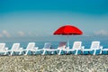 Sunbathing plastic beds and red umbrella on the beach Royalty Free Stock Photo