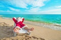 Sunbathing Santa Claus relaxing in bedstone on beach - Christmas Royalty Free Stock Photo