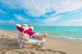 Sunbathing Santa Claus relaxing in bedstone on beach - Christmas Royalty Free Stock Photo