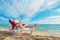 Sunbathing Santa Claus relaxing in bedstone on tropical beach Royalty Free Stock Photo