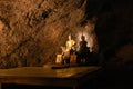 Sunbeam on Buddha statue in cave, Thailand