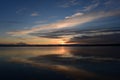 Sunbeam from the clouds at sunset on the mirror surface of the water  lake in the shadows and light of the reflection of the sky Royalty Free Stock Photo