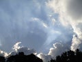 Sunbeam rays in the blue sky with clouds