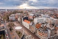 Sunbeams breaking through the cloud deck, with a panorama of Leuven, Flanders, Belgium.