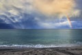 Sunbeams breaking through the sky forming an impressive rainbow