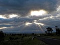 Driving in Australian countryside by sun rays through cloud gaps Royalty Free Stock Photo