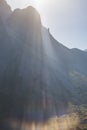 Sunbeams over a mountainous area, a mountain cliff with rocks in the shade in the highlands Royalty Free Stock Photo