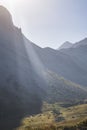 Sunbeams over a mountainous area, a mountain cliff with rocks in the shade in the highlands Royalty Free Stock Photo