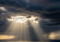 Sunbeams pierce through dense, dark clouds, Royalty Free Stock Photo