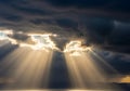 Sunbeams pierce through thick, dark clouds, Royalty Free Stock Photo