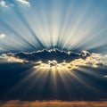 Sunbeams radiate through a cloud, creating a dramatic sky. The cloud appears dark Royalty Free Stock Photo