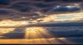 Sunbeams Radiating Through Dark Storm Clouds Over a Calm Ocean Horizon at Sunset light rays Royalty Free Stock Photo