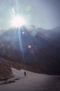 Sunbeams and traveler silhouette in Himalayan mountains.