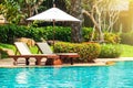 Sunbed with beach umbrella on side of swimming pool. Relaxing fa Royalty Free Stock Photo