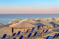 Sunbed, straw umbrella on beautiful rising sun beach background Royalty Free Stock Photo