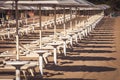 Sunbed and umbrellas repetition at the beach. Italian coast with a multitude seamsless of beach umbrellas, deckchairs for