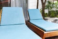 Sunbeds and blue fabric cushions beside the swimming pool inside the house Royalty Free Stock Photo