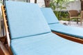 Sunbeds and blue fabric cushions beside the swimming pool inside the house Royalty Free Stock Photo