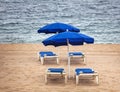 Sunbeds and blue umbrella on the sea sandy beach