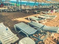 Sunbeds chaise longue at tropical empty beach and turquoise sea - Panorama of dream vacation in exclusive destination with white s Royalty Free Stock Photo