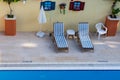Sunbeds on the edge of the swimming pool with clean water Royalty Free Stock Photo