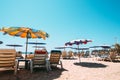 Sunbeds on tropical beach with calm sky