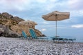 Sunbeds and umbrellas on Traganou beach at sunset, Rhodes island, Greece Royalty Free Stock Photo