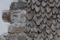 sunburned wooden shingles next stone wall on a facade