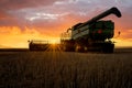 Sunburst through combine at sunset on the prairies in Saskatchewan, Canada