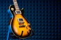 Sunburst electric guitar standing over acoustic foam panel background Royalty Free Stock Photo