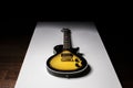 Sunburst guitar on white table