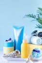 Suncare bottles, glasses, starfish palm leaves on a blue background. Beauty and care in the summer. Copy space