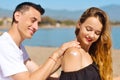 Suncare couple on a summer beach vacation have good skincare with high spf sunblock. Couple applying suncream. Handsome man Royalty Free Stock Photo