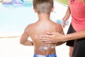 suncare on the swimming pool mother applying sunscreen on child son boy