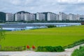 Green rice paddy field and green houses around residential area aroun Suncheoun city