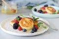 Sunday breakfast with cheesecake, honey, fresh berries and mint. Cottage cheese pancakes or curd fritters decorated honey Royalty Free Stock Photo