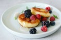 Sunday breakfast with cheesecake, honey, fresh berries and mint. Cottage cheese pancakes or curd fritters decorated honey Royalty Free Stock Photo