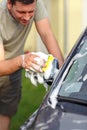 Sunday car wash- man washing car with a sponge and foam Royalty Free Stock Photo