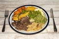 Sunday dinner of slow cooked shredded pulled beef on a plate with a knife and fork and plenty of vegetables Royalty Free Stock Photo