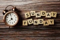 Sunday Funday alphabet letter with alarm clock on wooden background Royalty Free Stock Photo